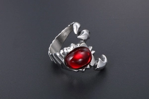 Close-up of vintage scorpion ring featuring a large red oval stone and steel finish
