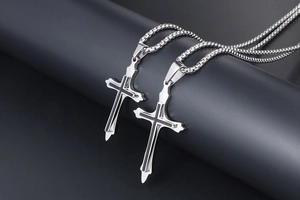 Close-up of titanium steel cross pendants with black enamel finish and box chains