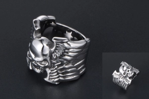 Vue détaillée du motif de crâne vintage avec ailes de plumes sur la bague en acier