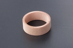 Macro detail of rose gold mesh ring showing fine woven stainless steel texture