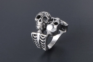Close-up of vintage silver skull ring with ornate carving and ribcage band detail