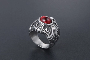Detailed side view of gothic stainless steel ring with red oval stone and tribal carvings