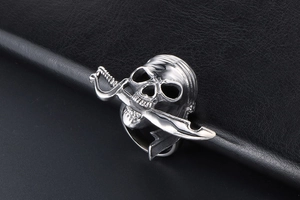 Détail d'une bague crâne de pirate avec sabre en bouche sur cuir noir élégant