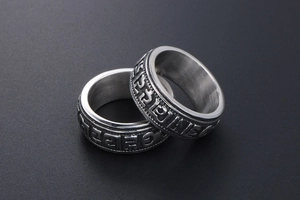 Detail of embossed Buddhist mantra on vintage silver titanium steel punk rings
