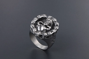 Detail of vintage skull ring for men with mechanical chain border and cross engraving
