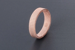Macro shot of flexible rose gold mesh ring crafted from woven titanium steel wire