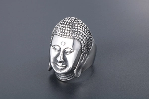 Detailed close-up of a vintage Buddha head ring in silver-tone titanium steel