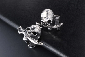 Macro d'une bague crâne de pirate avec bandana et sabre sur texture noire