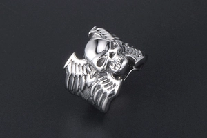 Détail d'une bague punk en acier inoxydable avec crâne et gravures d'ailes latérales