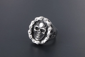 Detailed view of punk skull ring with mechanical chain border and cross cutout