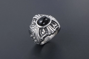 Close-up of vintage punk ring featuring an oval black gemstone and gothic relief patterns