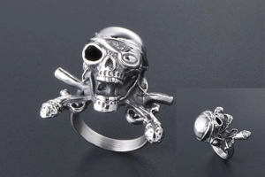 Macro view of vintage silver pirate skull ring with flintlock pistols in punk style