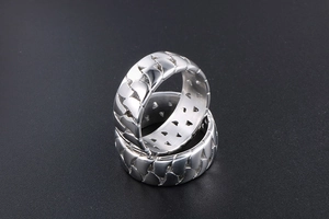 Close-up of men's silver stainless steel rings with detailed scale-pattern chain texture