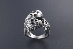 Macro detail of gothic double skull ring featuring vintage floral engraving and rib texture