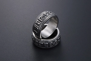 Macro view of retro punk titanium steel rings featuring embossed Six Syllable Mantra text
