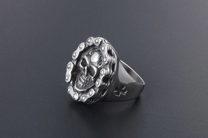 Macro view of vintage skull ring with chain border and side cross detail in aged steel