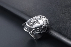 Macro view of vintage silver Buddha head ring with detailed matte finish on black leather