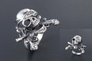 Macro detail of gothic pirate skull ring in vintage stainless steel with crossbones
