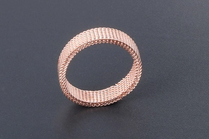 Macro view of rose gold titanium steel mesh ring showing detailed woven texture and pattern