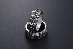 Macro shot of titanium steel punk ring featuring embossed Buddhist six-word mantra details