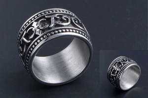 Macro view of vintage silver steel ring with gothic relief patterns and beaded edges
