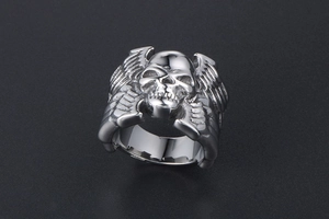 Vue macro d'une bague punk en acier inoxydable avec crâne et ailes argentées détaillées
