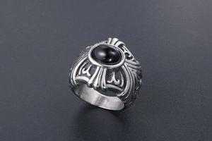 Detailed view of punk titanium steel ring with black oval stone and embossed patterns
