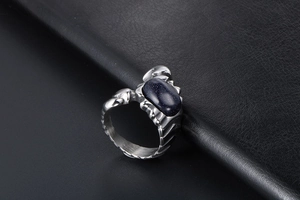 Macro shot of oval blue goldstone inlay on a vintage grooved steel ring for men
