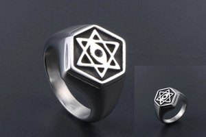 Close-up of vintage steel ring featuring hexagonal face and engraved all-seeing eye star