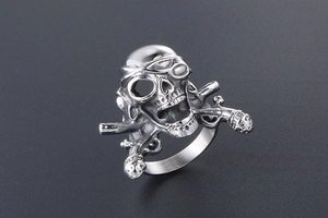 Detailed macro view of vintage stainless steel pirate skull and crossed muskets ring