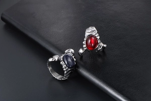 Close-up of vintage gothic titanium steel rings with red zircon and blue goldstone on leather