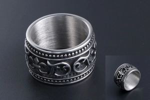 Detail of wide silver titanium steel ring with gothic floral relief and beaded edges