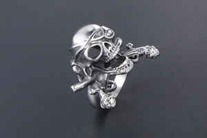 Detailed view of punk skull ring with phallic crossbones design in silver titanium steel