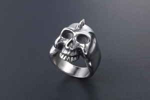 Detailed close-up of a punk skull ring with silver spike mohawk in aged titanium steel