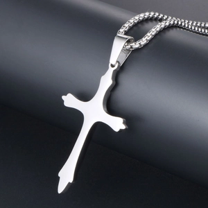 Polished silver cross pendant necklace with wave edges on black cylinder stand