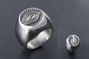 Macro detail of vintage stainless steel signet ring with radial eye engraving and textures
