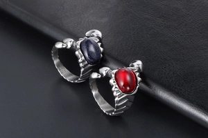Macro detail of gothic scorpion titanium steel rings with blue and red gemstones