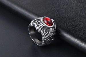 Macro detail of retro punk titanium steel ring featuring red oval stone and tribal carvings