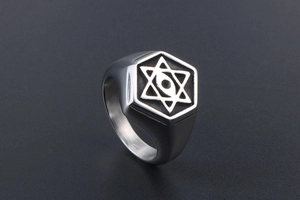 Macro detail of men's hexagonal signet ring with vintage star and eye engraving
