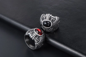 Macro detail of gothic titanium steel rings with red and black stones and engraved crosses