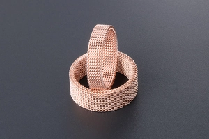 Detailed close-up of rose gold stainless steel rings with precision woven mesh texture