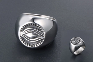 Macro shot of silver titanium steel ring featuring detailed evil eye engraving and finish
