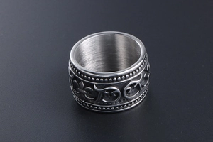 Macro shot of vintage titanium steel ring with embossed cross and beaded edge detailing