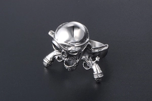 Macro detail of silver gothic skull ring with vintage crossed pistols and dark patina