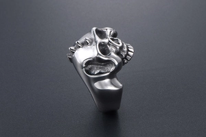 Detailed close-up of punk skull ring with side spikes in silver stainless steel
