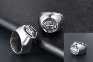 Detailed macro of vintage stainless steel signet ring with evil eye and radial sunburst