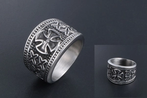 Detail of vintage punk stainless steel ring featuring embossed cross and beaded edges