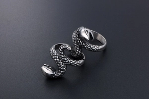 Detailed macro view of the realistic snake scale texture on a silver punk double finger ring