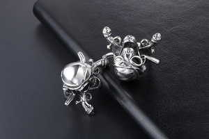 Detailed view of skull and hair stylist tools on a polished silver stainless steel ring