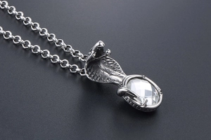 Detailed view of cobra pendant with large clear crystal and textured silver scales
